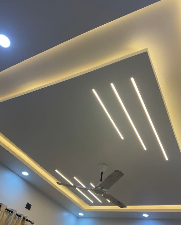 Gypsum false ceiling with linear LED strip lighting design and ceiling fan, Chandigarh living room