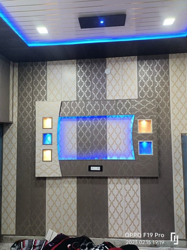 PVC panel TV unit wall design with textured finish and blue LED accent lighting, Chandigarh
