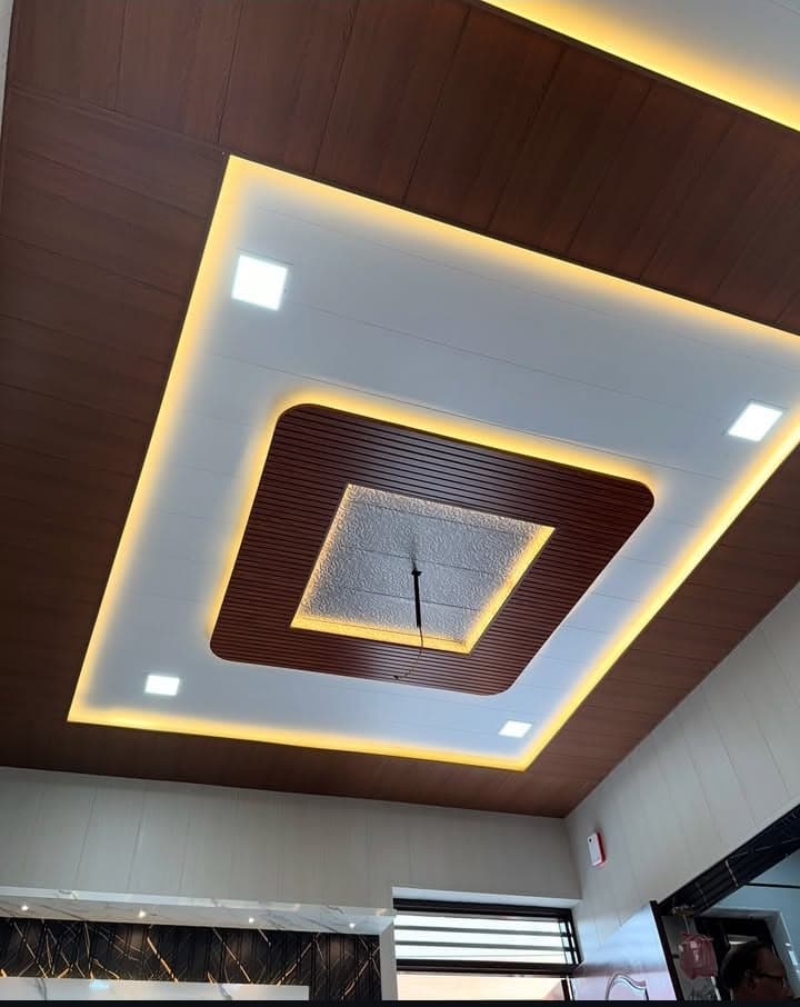 PVC false ceiling with dark wood-tone finish and warm cove lighting border, Chandigarh interior