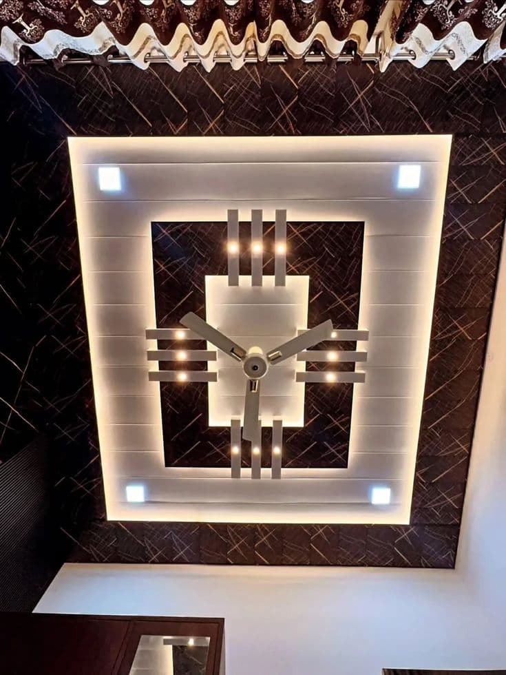 PVC panel ceiling in dark marble-pattern finish with warm cove lighting and ceiling fan